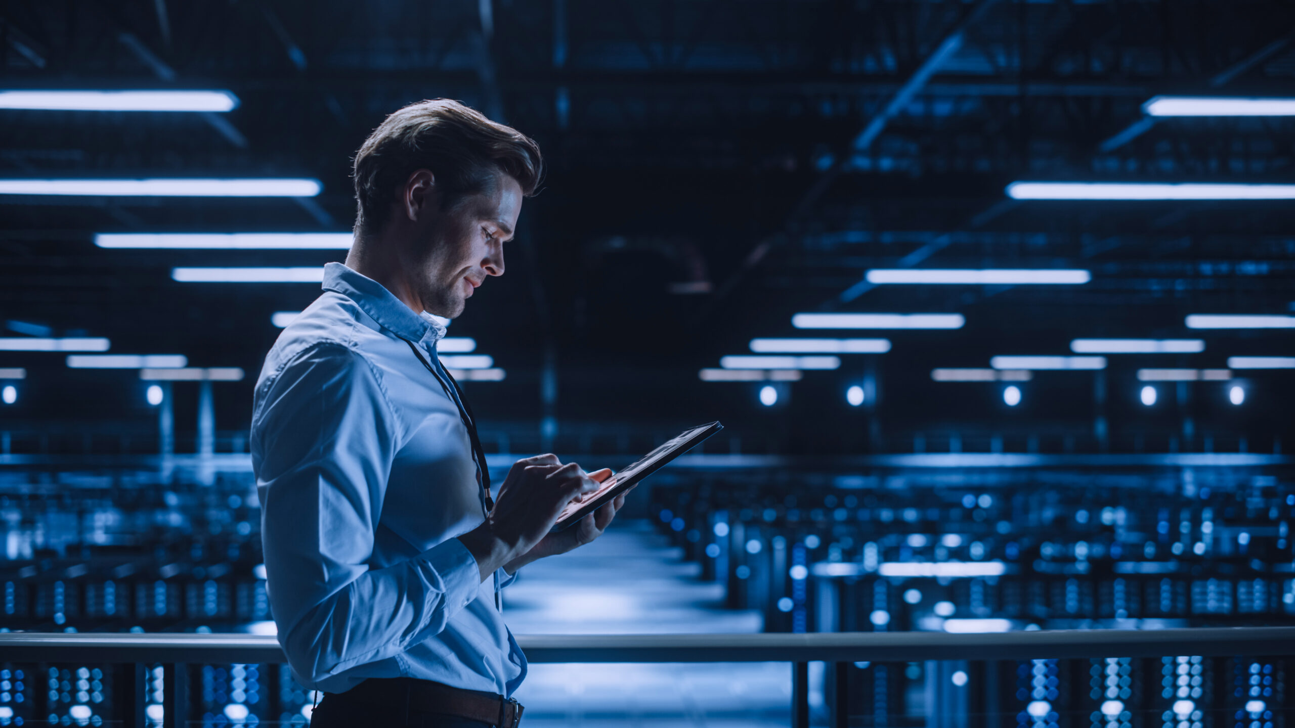 Handsome Smiling It Specialist Using Tablet Computer In Data Cen