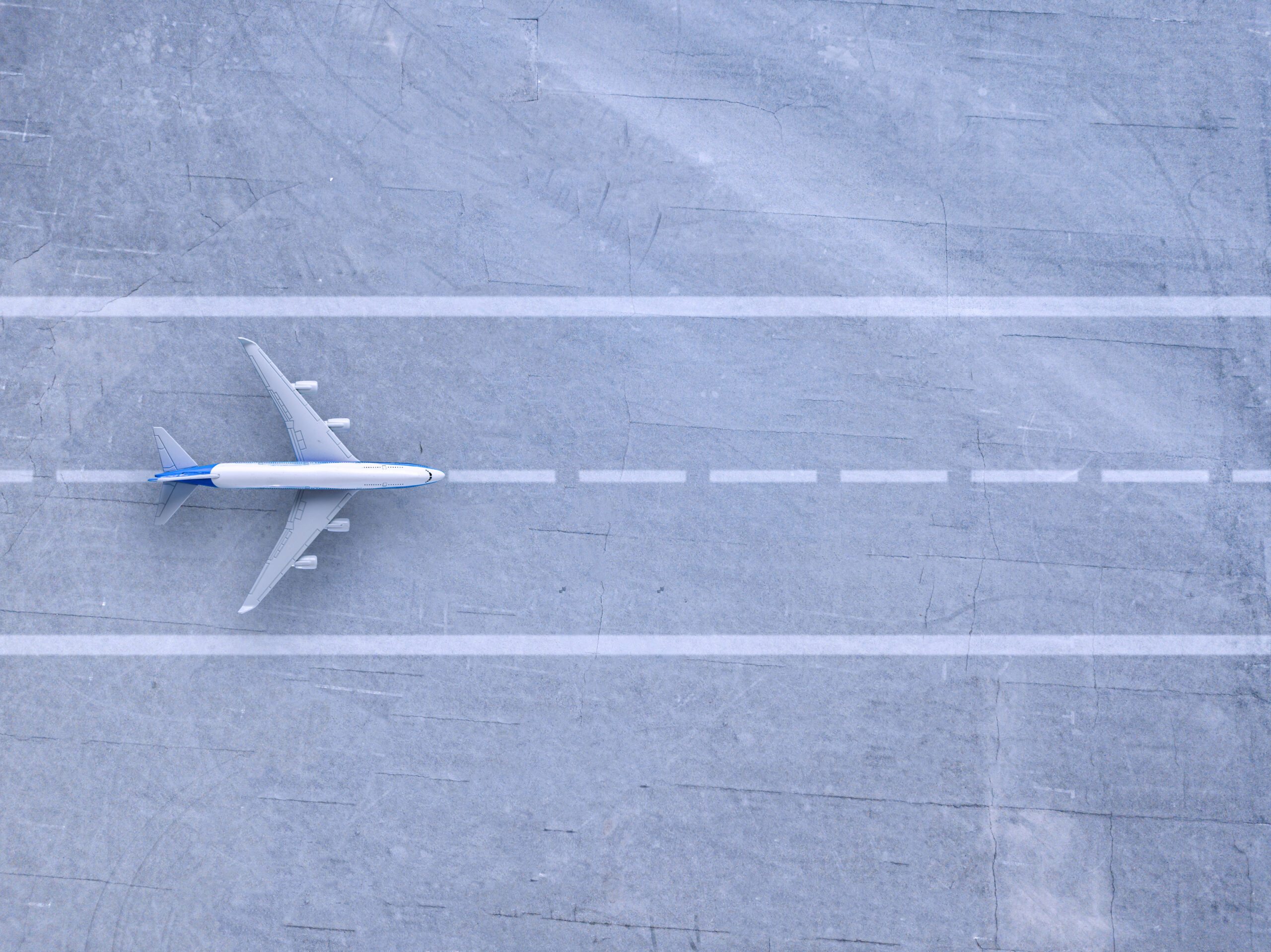 An aeroplane positioned on a runway viewed from above, highlighting aircraft alignment with runway markings.